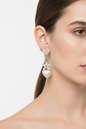 Model wearing gold crystal and pearl heart drop earrings, no logo
