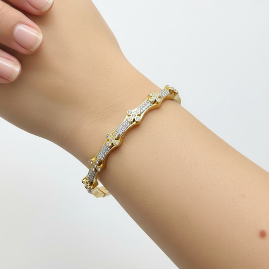 Model wrist wearing gold wavy crystal bangle bracelet