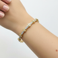 Model wrist wearing gold wavy crystal bangle bracelet